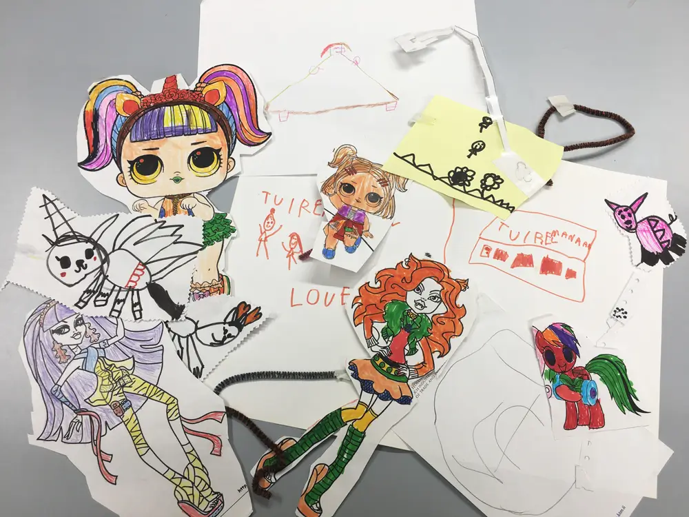 A collage featuring hand-drawn and ready-made coloured and cut-out figures, as well as drawn images on paper. The figures include a variety of characters, such as a doll, people, and a unicorn, and they are decorated with different colours and materials, such as felt-tip pens and pipe cleaners.