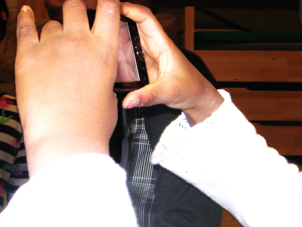 A close-up of a child&rsquo;s hands as they take photos with a digital camera.